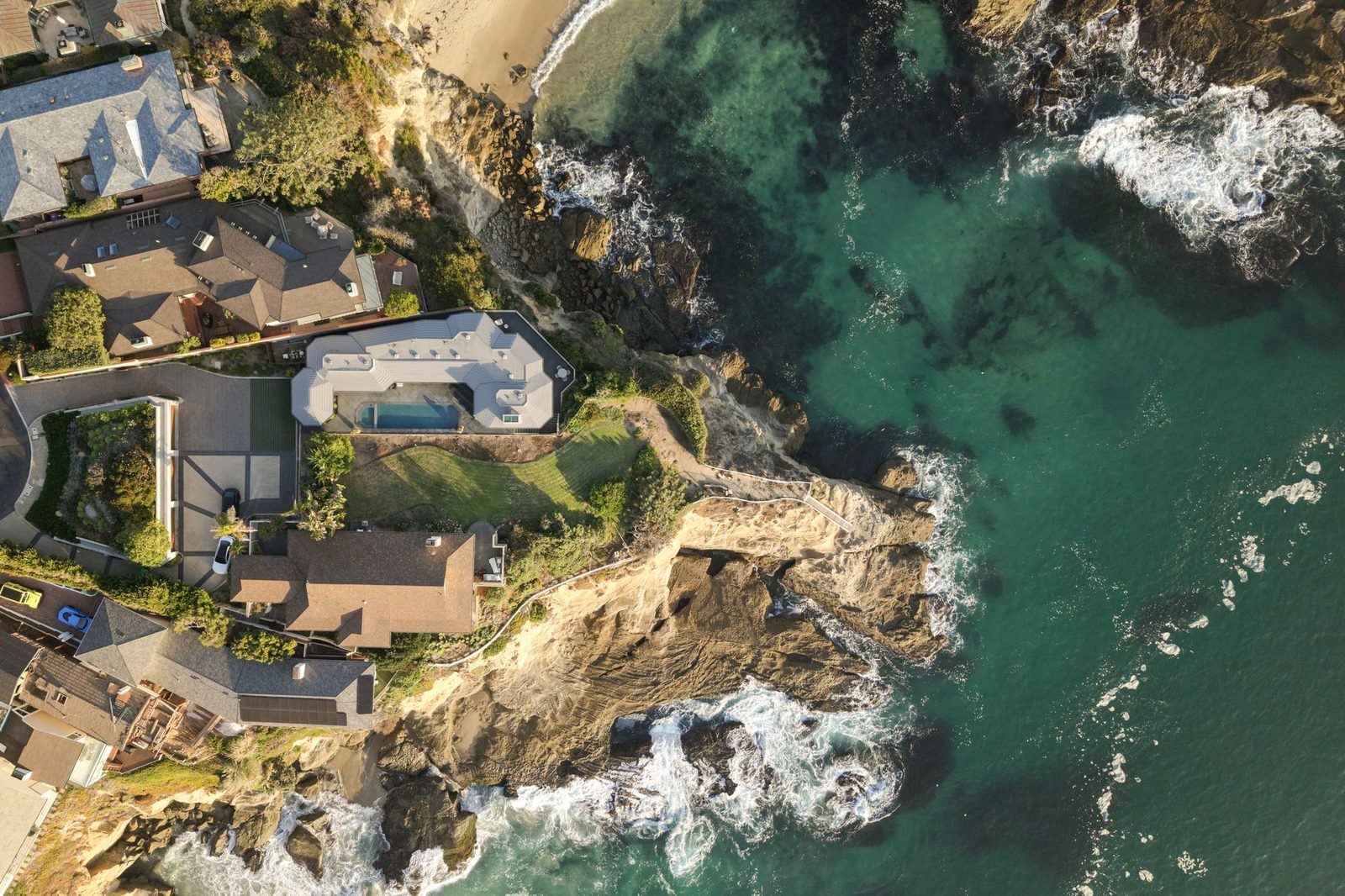 Aerial photograph of an oceanfront home above a cove — 3 N La Senda Drive by Jacob Schrader