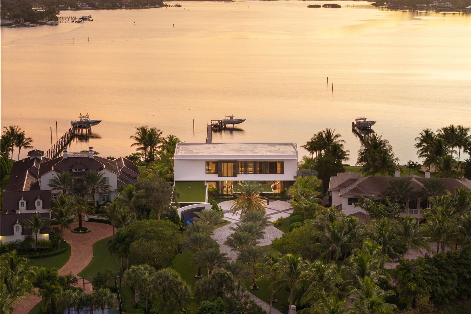 Golden-hour aerial of a waterfront modern home — 5211 Pennock Point by Jacob Schrader